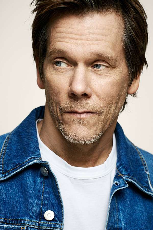 Mann mit blauen Augen und Stoppeln trägt Jeansjacke und weißes T-Shirt. — Kevin bacon Bilder