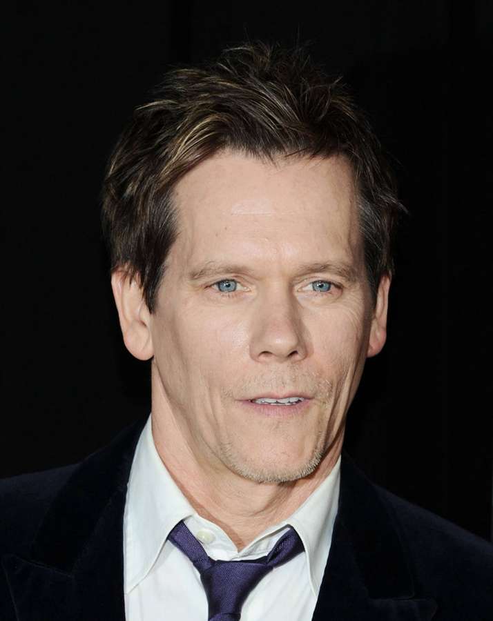 Kevin Bacon in einem dunklen Samtanzug und lila Krawatte, der in die Kamera schaut. — Kevin bacon Wallpaper