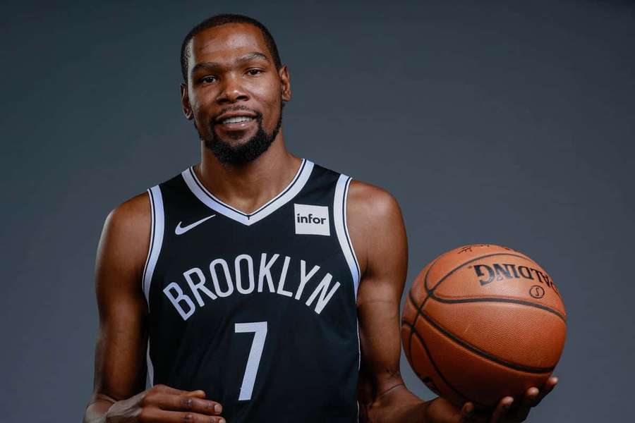 Kevin Durant in Brooklyn Nets jersey holding a basketball in studio portrait. — Kevin Durant Nets Wallpaper
