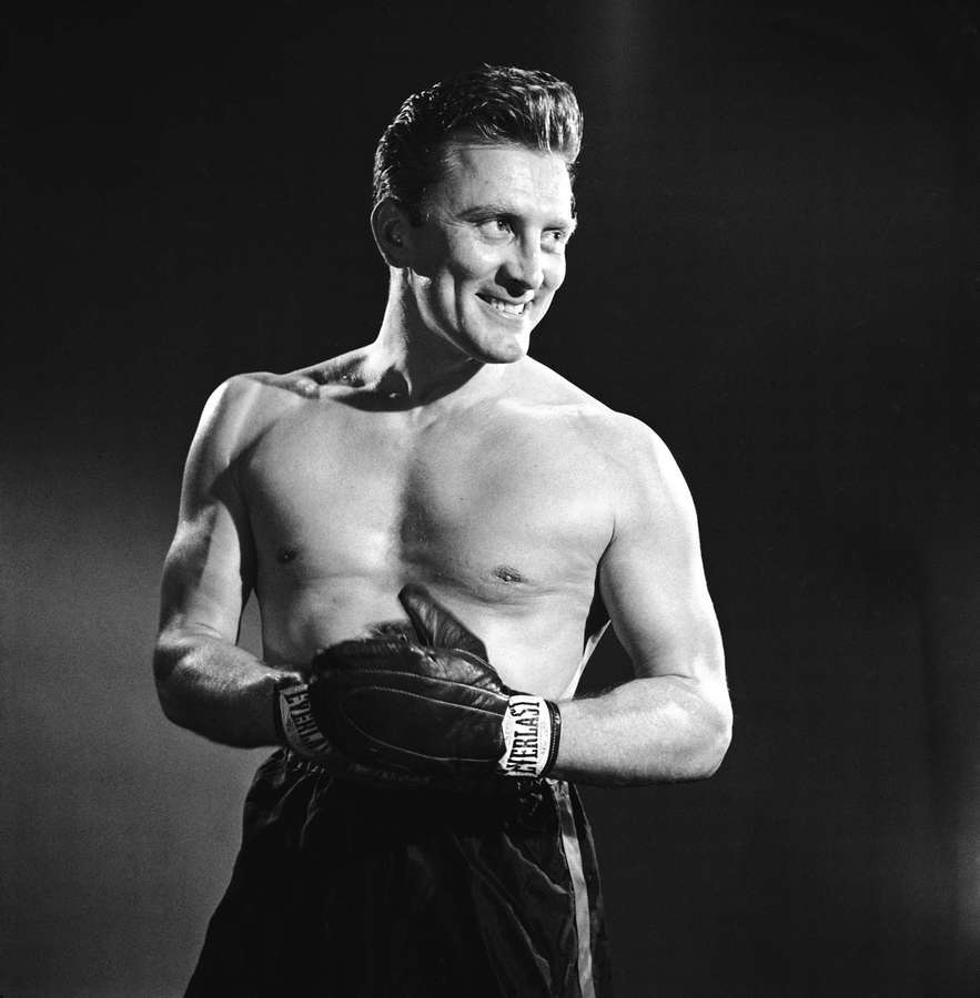 Ein lächelnder Boxer in Everlast-Handschuhen, der in einem Studio posiert — Kirk Douglas Bilder