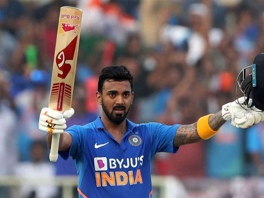 Cricketspelare i blå tröja firar med slagträ och hjälm upphöjda. — KL Rahul Bakgrundsbilder