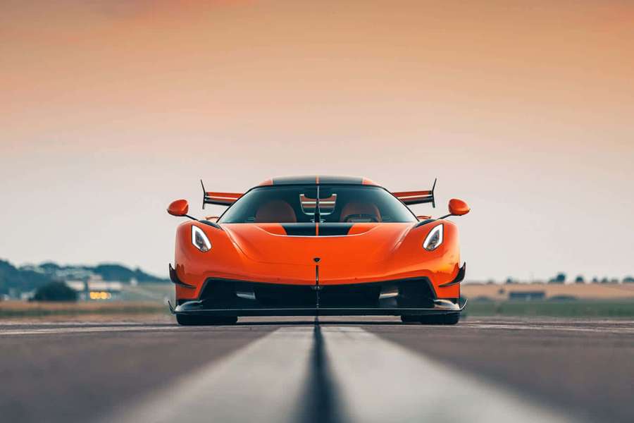 Orange hypercar on runway at sunset with glowing sky — Koenigsegg Wallpaper