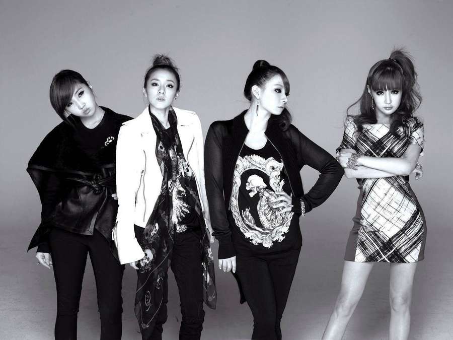 Four women in stylish outfits posing in a studio with confident expressions. — Korean Aesthetic Background
