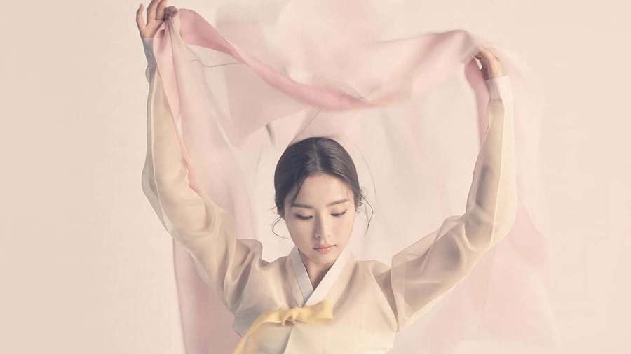 Woman in traditional hanbok holding flowing pink silk scarf with serene expression. — Korean Aesthetic Computer Wallpaper