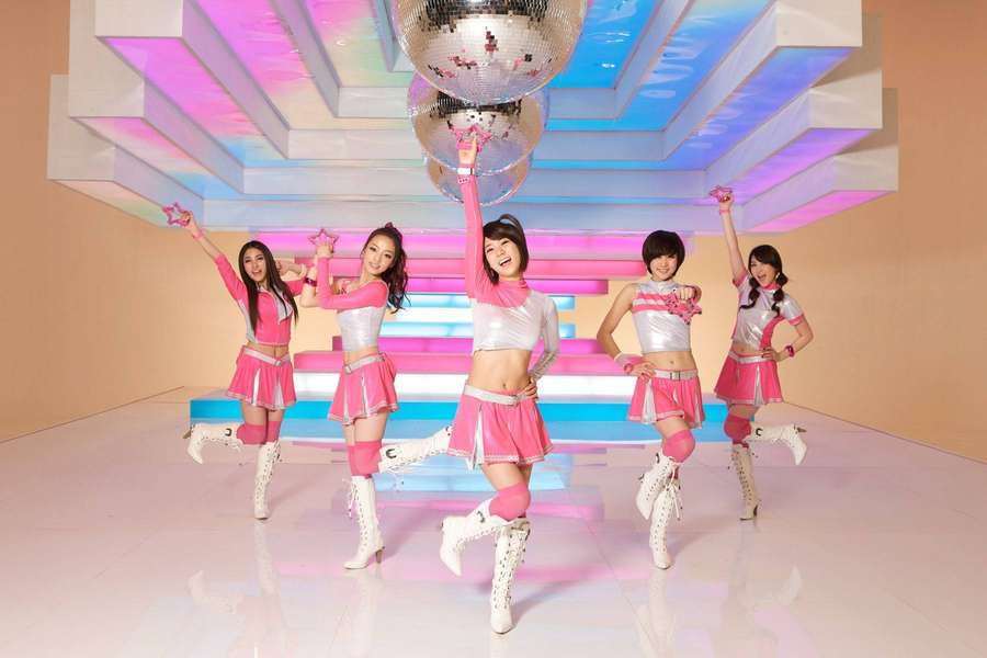 Viisi naistanssijaa vaaleanpunaisissa ja hopeisissa asuissa poseeraa diskopallon alla neonvalaistussa studiossa. — Kpop Taustakuvat