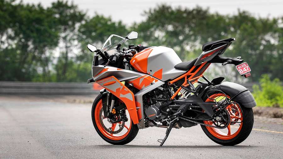 Orange and silver sport motorcycle parked on a road with trees behind. — Ktm Rc 200 Wallpaper