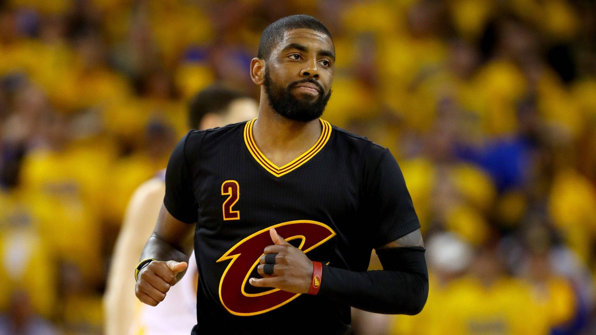 Basketbollspelaren Kyrie Irving i svart tröja springer på planen med publik bakom. — Kyrie Bilder