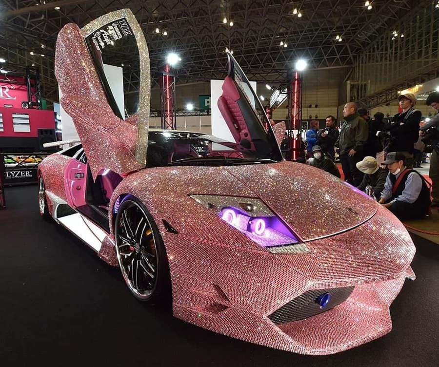 Lamborghini rosa cubierto de cristales con puertas abiertas en el salón del automóvil. — Lamborghini Rosa Fondos de pantalla
