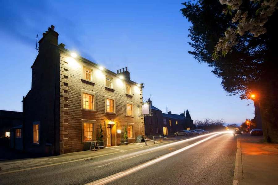 Stone building with warm lights at dusk with streaking car lights on street — Lancaster United Kingdom Wallpaper
