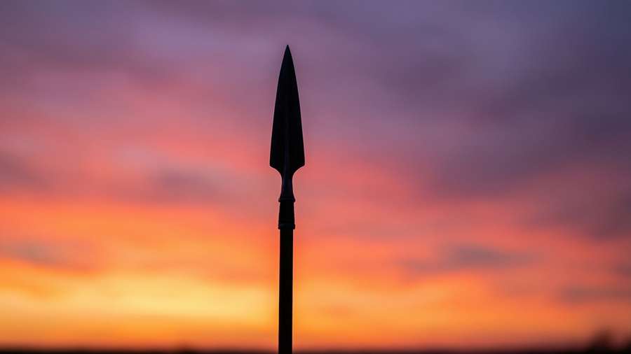 A silhouette of a lance against a colorful sunset sky. — Lance Wallpaper