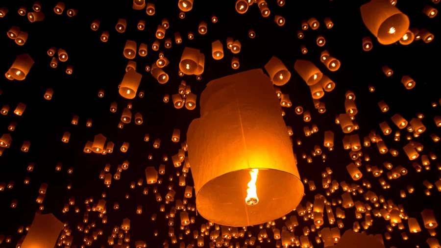 Hundreds of glowing sky lanterns floating upward in the night sky. — Lantern Background