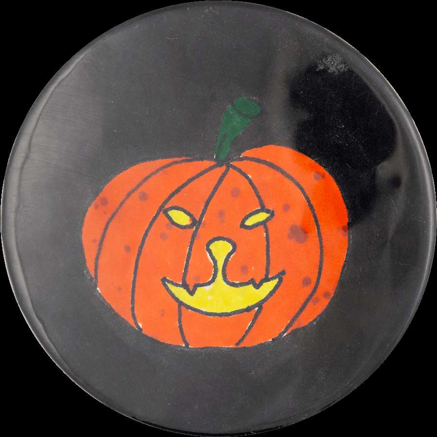 A cartoon pumpkin with a smiling face on a dark button. — Lantern PNG