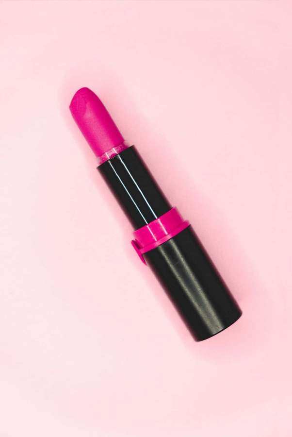 Un lápiz labial rosa brillante con tubo negro sobre una superficie rosa. — Lápiz labial rosa Fondos de pantalla
