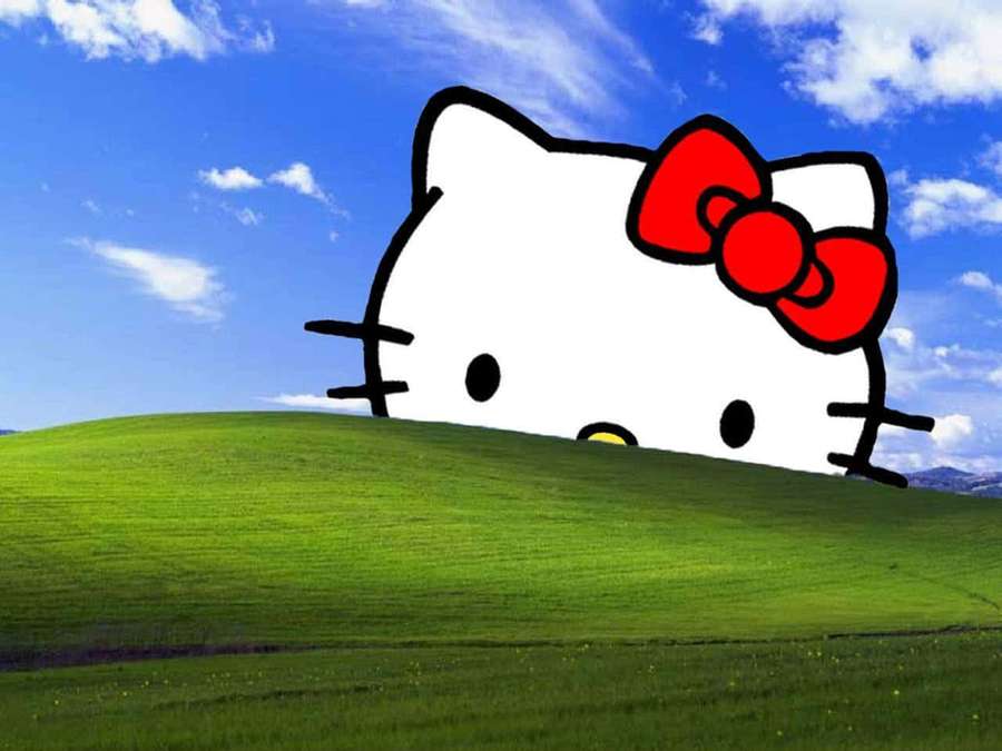 Hello Kitty asomando sobre una colina verde bajo un cielo azul con nubes. — Laptop Hello Kitty Fondos de pantalla