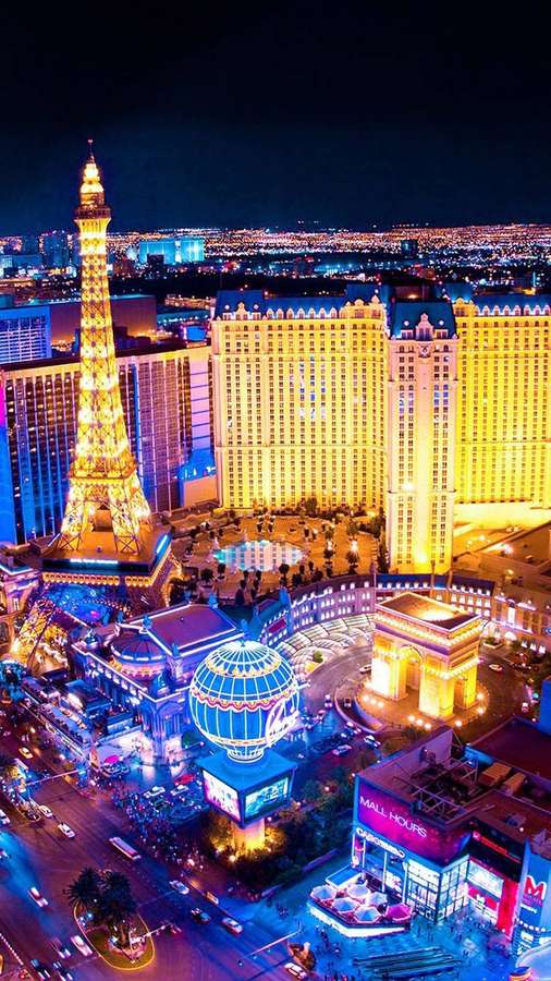 Las Vegas skyline om natten med glødende Eiffeltårn-replika og gyldne hoteller. — Las Vegas iPhone Wallpapers