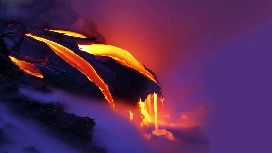 Lava flows glowing orange down a dark cliff at night with purple sky — Lava Background