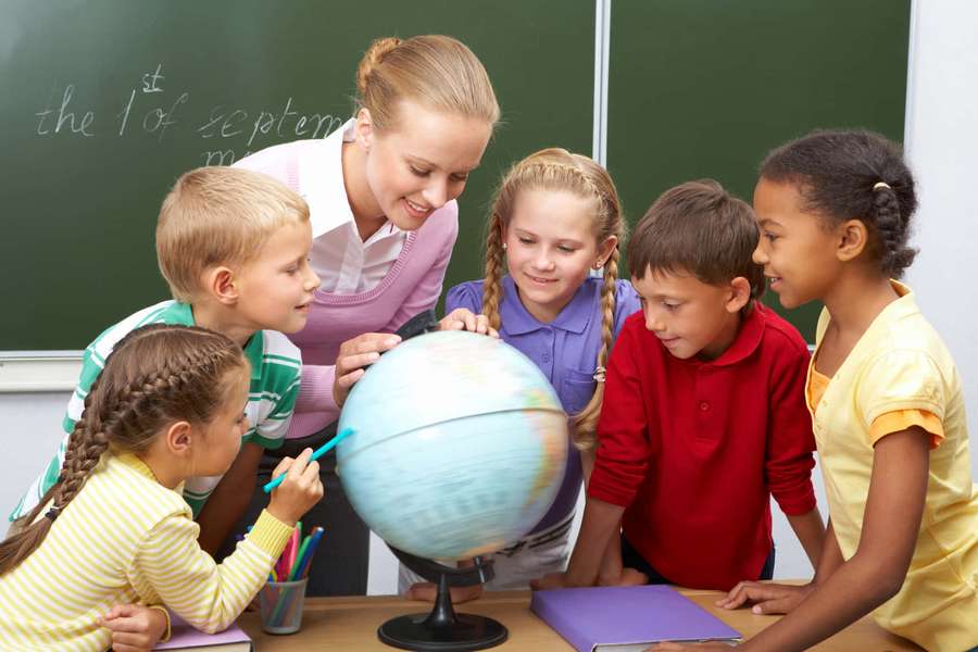 Teacher and students gathered around a globe in a classroom setting. — Learning Picture
