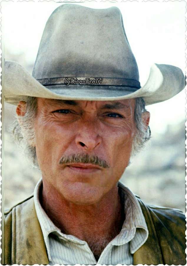 Close-up of a rugged cowboy with a mustache and hat in a desert setting. — Lee Van Cleef Wallpaper