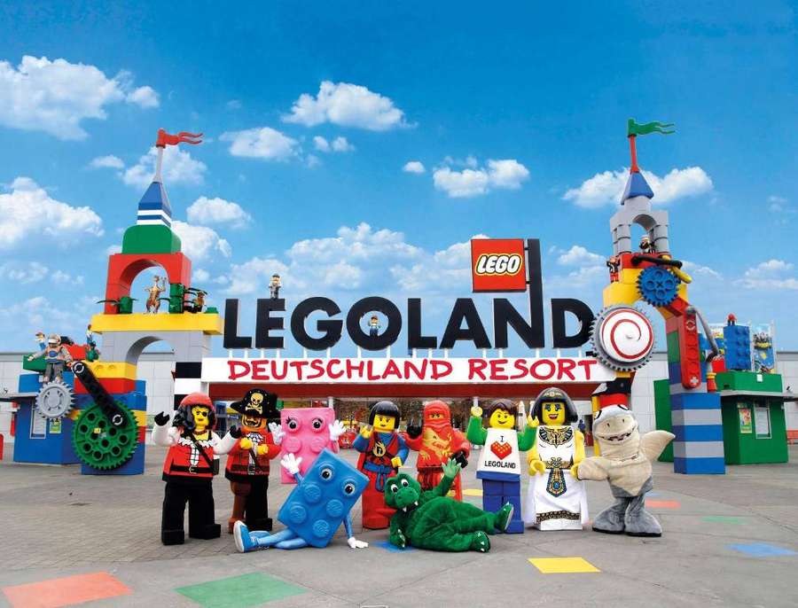 Group of LEGO characters at LEGOLAND Deutschland Resort entrance on sunny day. — Legoland Background