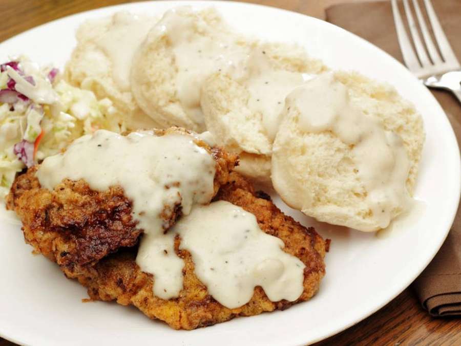 Frango frito com molho, biscoitos e salada de repolho em uma mesa de madeira. — Leitelho Papéis de Parede