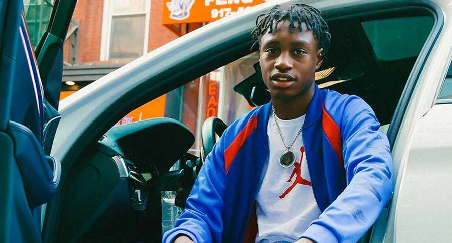 Ung mand i blå jakke og Jordan-trøje siddende i bil på bygade. — Lil tjay Wallpapers