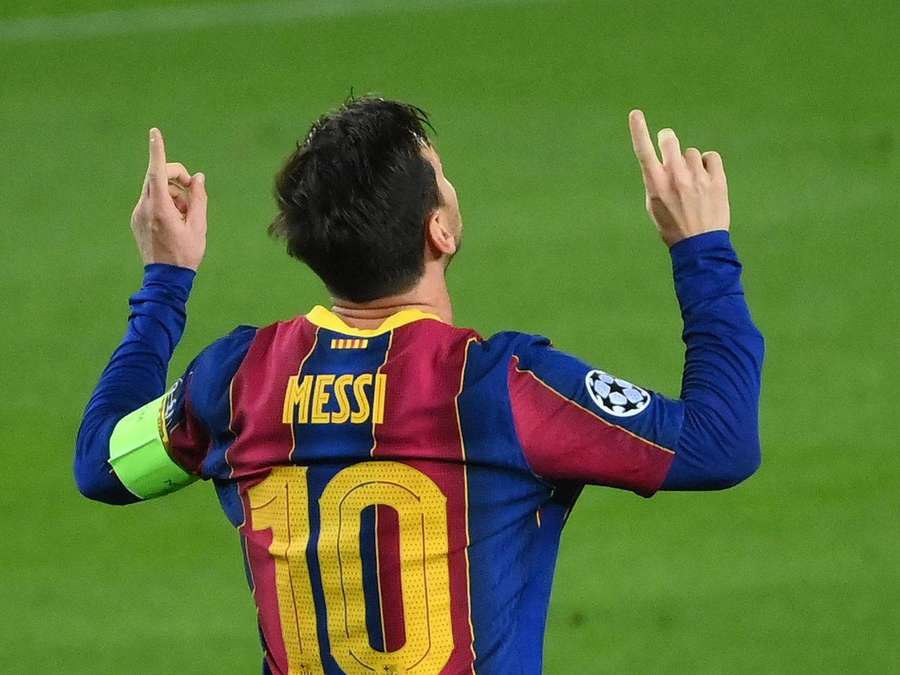 Jugador de fútbol Messi celebrando con ambas manos levantadas en un campo verde. — Lionel Fondos de pantalla