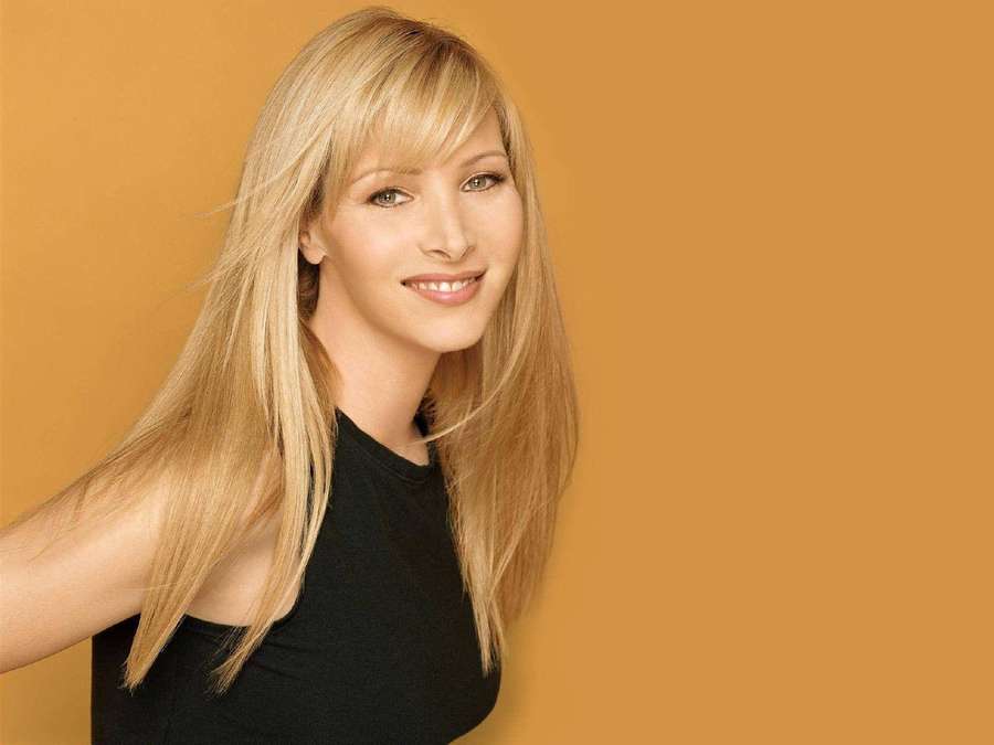 Blonde Frau lächelt in einem schwarzen Oberteil vor gelbem Hintergrund. — Lisa kudrow Wallpaper