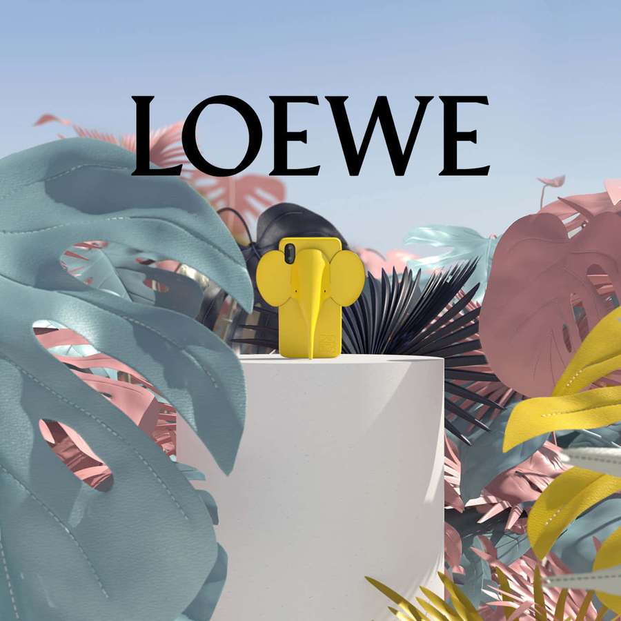 Yellow elephant phone case displayed among colorful tropical leaves. — Loewe Wallpaper