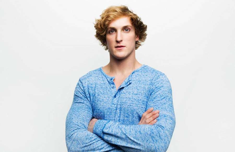 Young man with curly blonde hair in blue shirt arms crossed studio portrait — Logan Paul Wallpaper