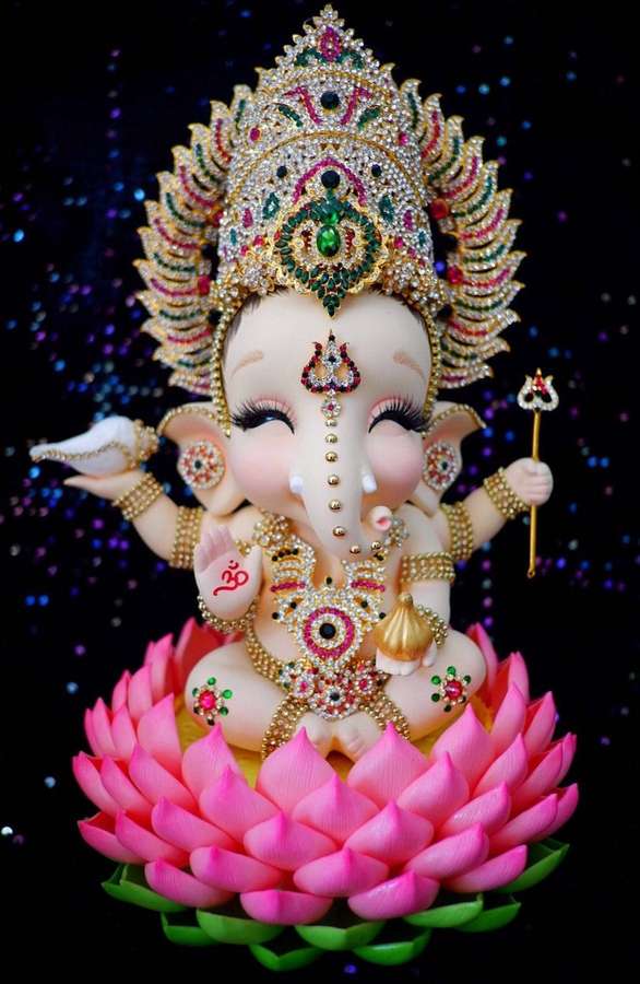 Ganesha-Statue mit Juwelen geschmückt, sitzend auf einer rosa Lotusblüte vor einem sternenübersäten Hintergrund. — Lotus Bilder