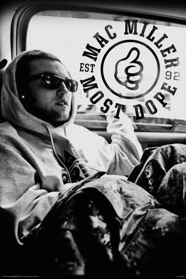 Mac Miller in einem Hoodie und Sonnenbrille, der in einem Auto sitzt, mit einem 'Most Dope'-Logo auf dem Fenster. — Mac Miller Bilder