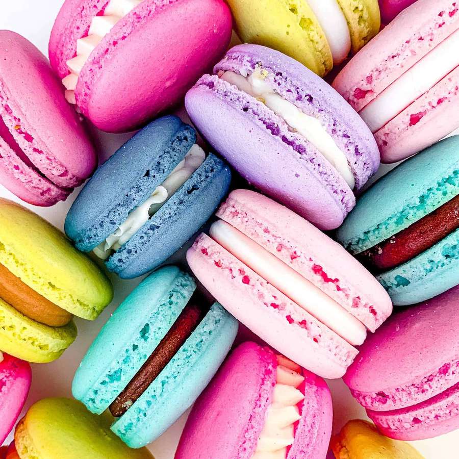 A pile of colorful macarons with creamy fillings. — Macaron Wallpaper