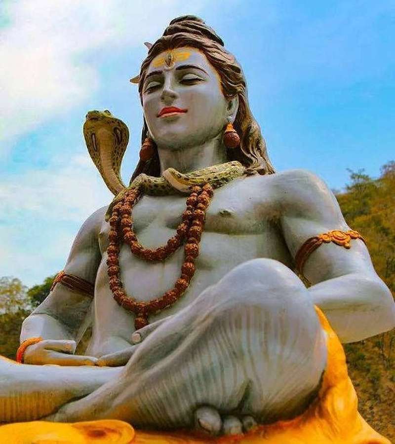 Estátua do Senhor Shiva com cobra, expressão serena, ao ar livre sob céu azul. — Mahadev HD Papéis de Parede