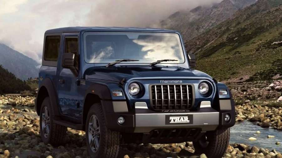 Blue Mahindra Thar SUV parked on rocky riverbank near mountains — Mahindra Thar 2021 Wallpaper