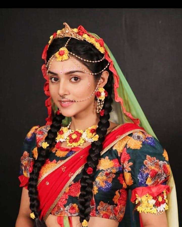 Woman in colorful traditional Indian dress with floral patterns and jewelry. — Mallika Background