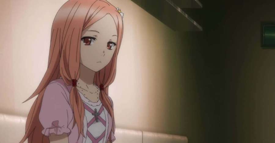Anime girl with peach hair and red eyes looking down sadly indoors. — Manami Okuda Wallpaper