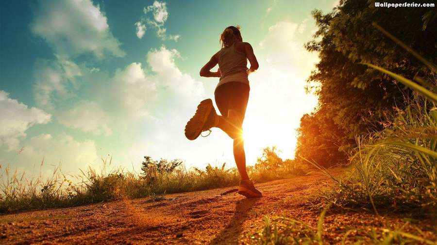 Persona corriendo en un sendero de tierra durante el atardecer con árboles y cielo al fondo — Maratón Fondos de pantalla