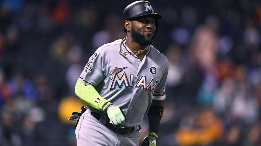 Baseball player in Miami Marlins uniform walking on field at night. — Marcell Ozuna Wallpaper