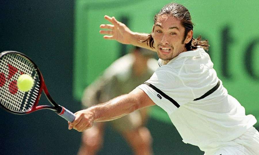 Tennis player lunges to hit ball with racket on court. — Marcelo Rios Wallpaper