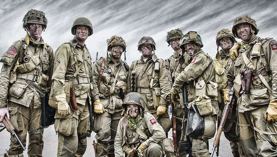 Grupp av WWII-soldater i full utrustning poserar under stormig himmel — Marines Bakgrundsbilder