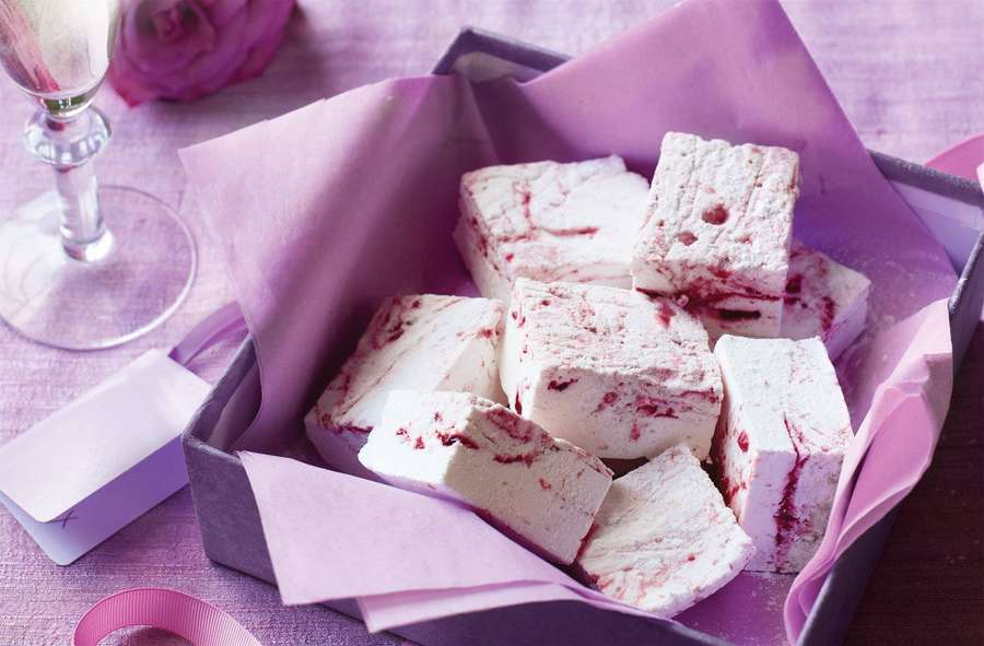 Purple box filled with raspberry swirl marshmallows with champagne flute and rose nearby. — Marshmallow Background