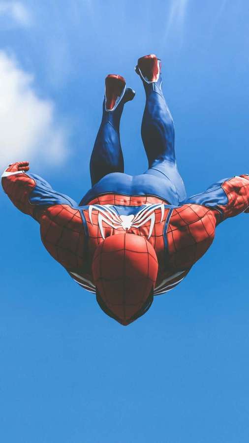 Spiderman flying upside down in a blue sky with white clouds. — Marvel Ps4 Wallpaper