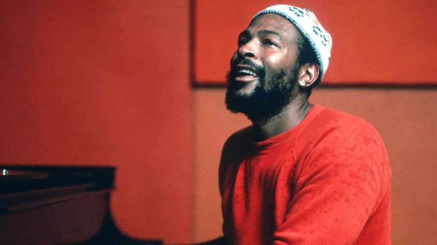 Man with beard and knit cap smiling at piano in red studio — Marvin Gaye Wallpaper