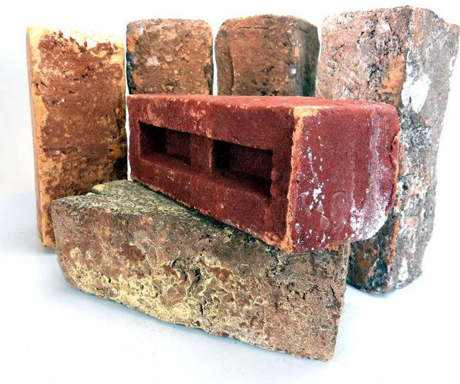 Pilha de tijolos desgastados com texturas e tons terrosos variados. — Material Desktop Papéis de Parede