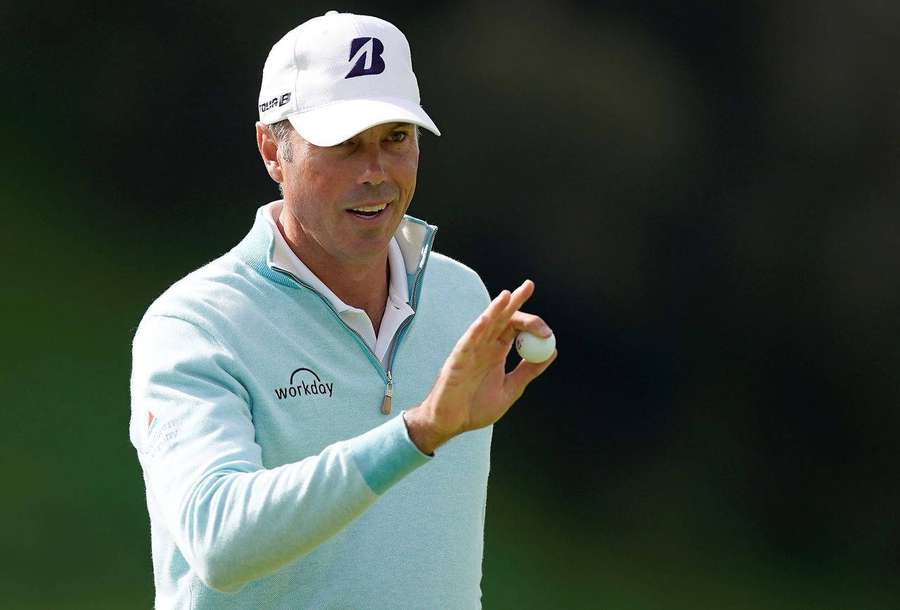 Golfer holding golf ball in light blue sweater and white cap — Matt Kuchar Wallpaper