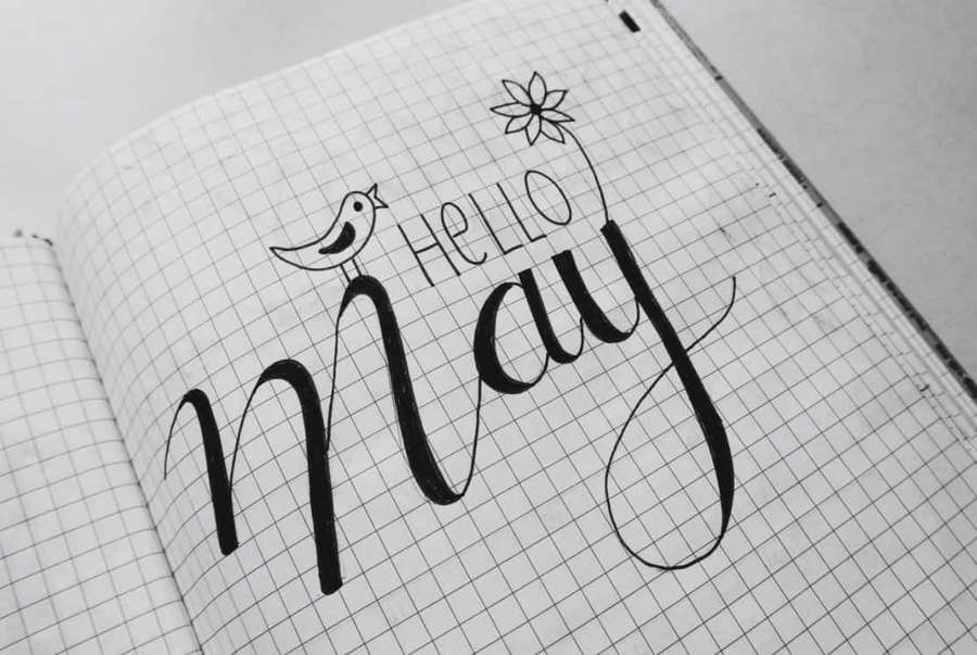 Handwritten 'Hello May' with bird and flower on grid paper notebook. — May Background