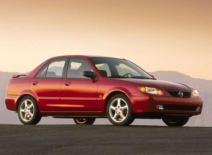 Red Mazda 6 sedan parked on asphalt with mountains at sunset. — Mazda Protege Wallpaper
