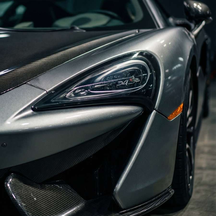 Close-up of McLaren 540C badge and headlight. — Mclaren 540c Wallpaper