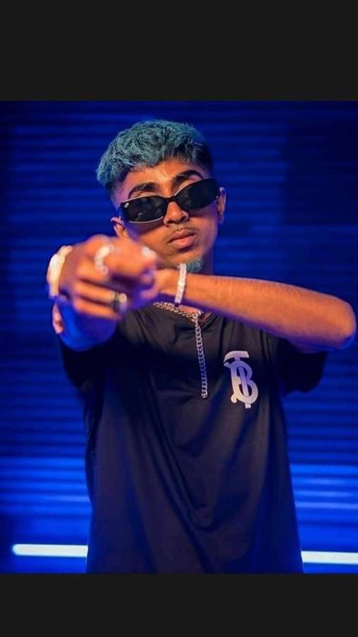 Junger Mann mit blauen Haaren und Sonnenbrille zeigt auf den Betrachter in blauem Licht. — Mcstan Wallpaper
