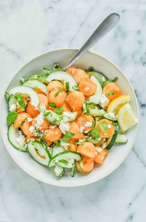 Frischer Karotten-Gurken-Salat mit Fetakäse und Zitronenspalten in einer weißen Schüssel. — Melone Wallpaper